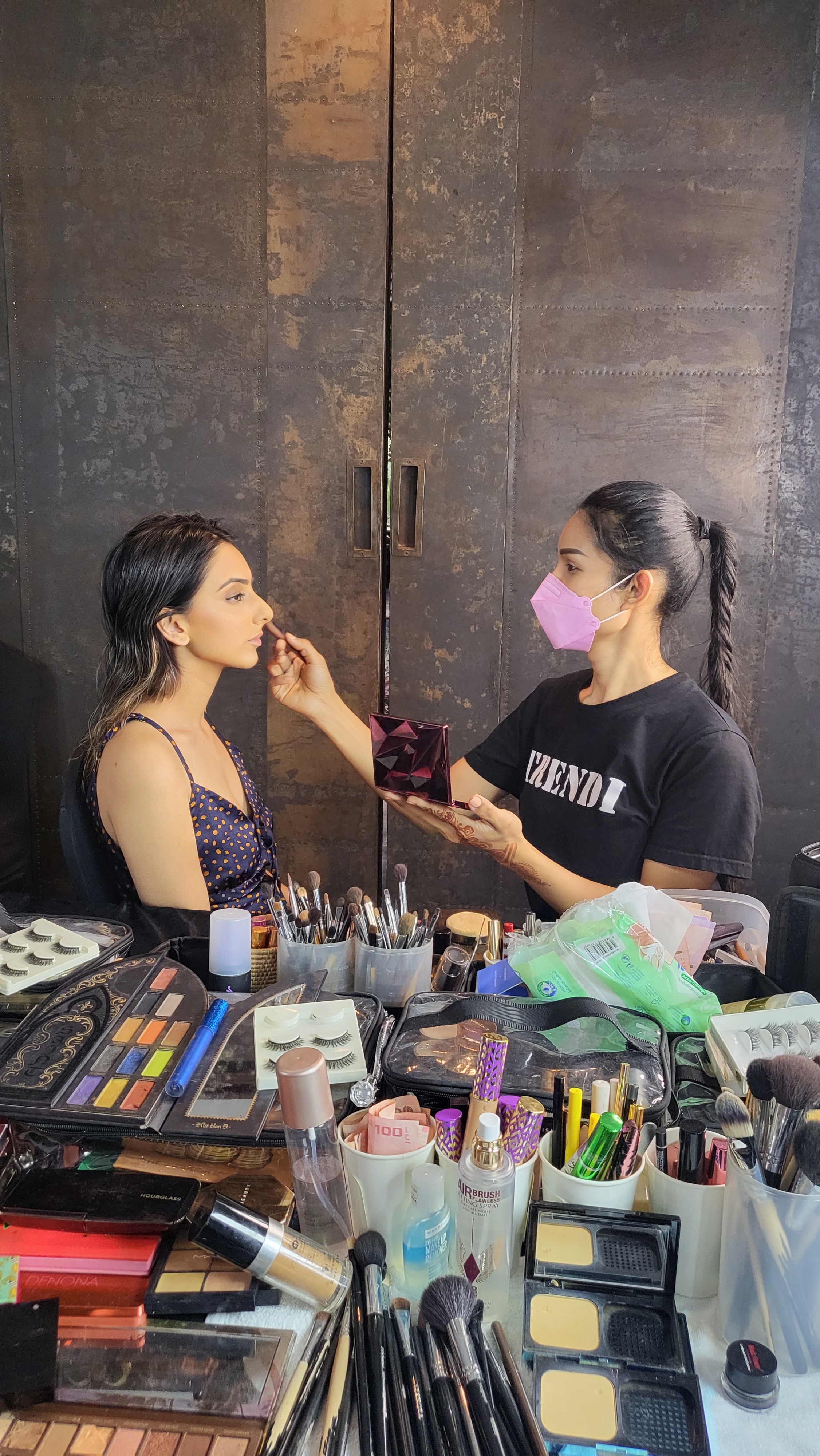 Kookkai applying Indian bridal makeup on a client